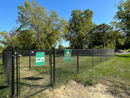 a chain link fence with green signs on it