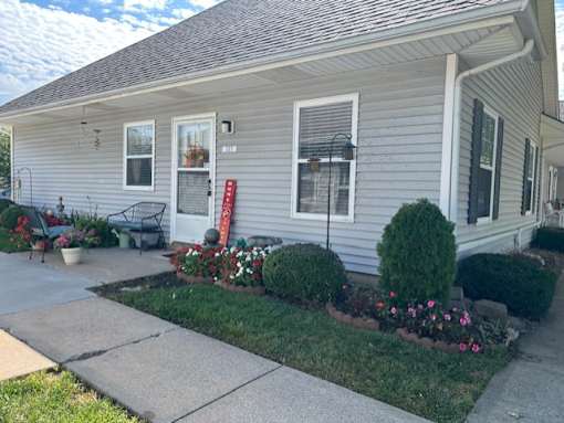 A house with a grey siding and a red mailbox.