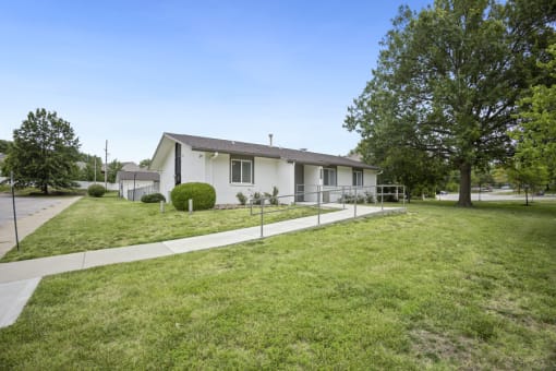 a white house with a yard and a sidewalk