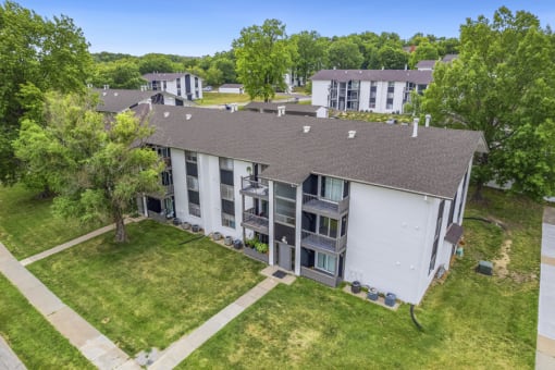 an aerial view of a building with green grass and trees