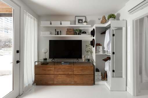 A modern living room with a flat screen TV and a wooden cabinet.