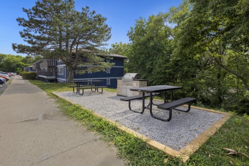 a picnic area with benches and a picnic table next to a sidewalk