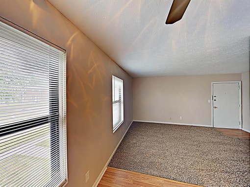 an empty living room with a large window and a door