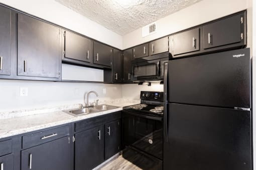 a kitchen with black appliances and black cabinets