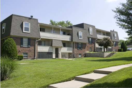 Apartment complex with a green lawn in front.