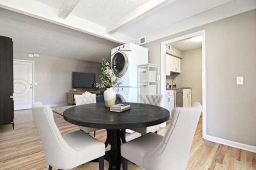 A modern dining room with a round table and white chairs.