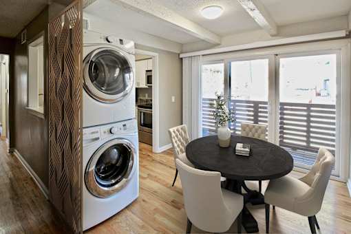 A modern laundry room with a washer and dryer built into a cabinet.