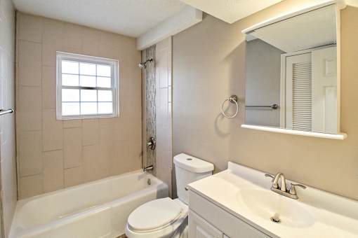 A bathroom with a toilet, sink, and bathtub.