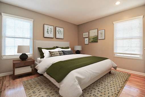 A bedroom with a large bed and a green blanket.