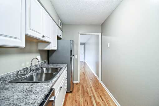 A kitchen with a granite countertop and white cabinets.