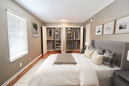 A bedroom with a large bed and a walk-in closet.