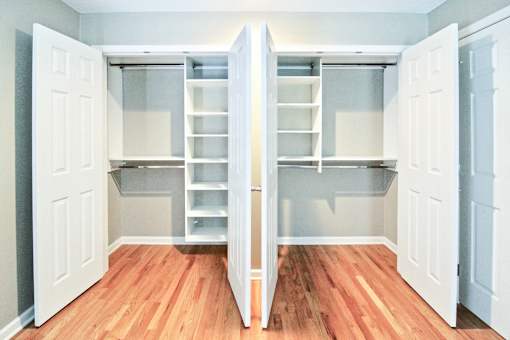 A kitchen with white cabinets and a wooden floor.