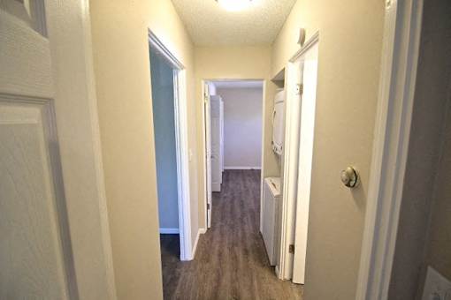 A hallway with a white door on the right and a white door on the left.