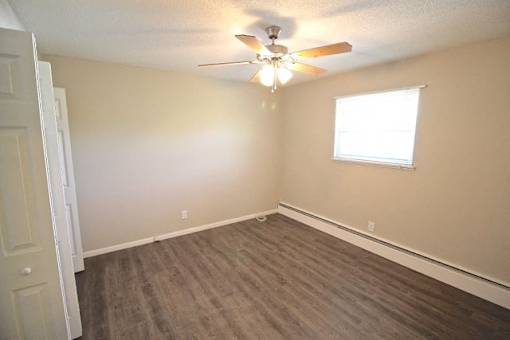 A room with a ceiling fan and a window.
