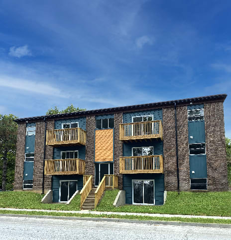A large apartment building with a balcony on the second floor.
