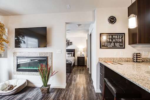 A modern kitchen with a fireplace and a clock on the wall.