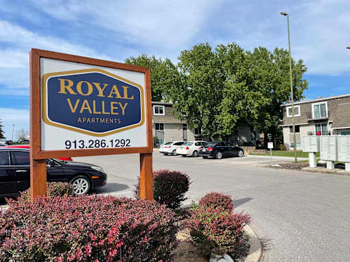 A sign for Royal Valley Apartments with a phone number on it.