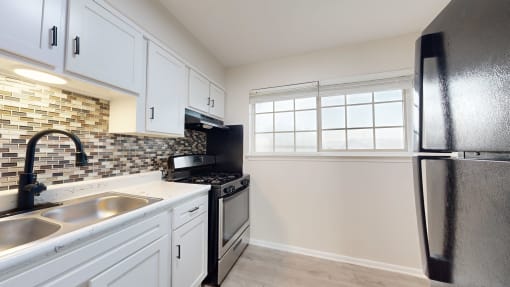 a kitchen with stainless steel appliances and white cabinets