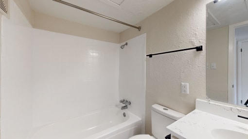 a bathroom with a white toilet and a tub and a sink
