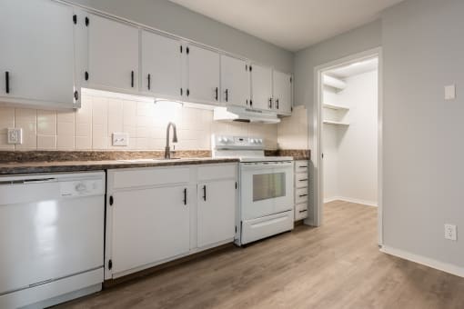 a kitchen with white cabinets and white appliances