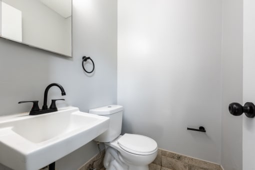 a bathroom with a sink toilet and mirror