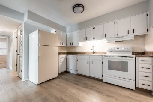 a kitchen with white cabinets and white appliances