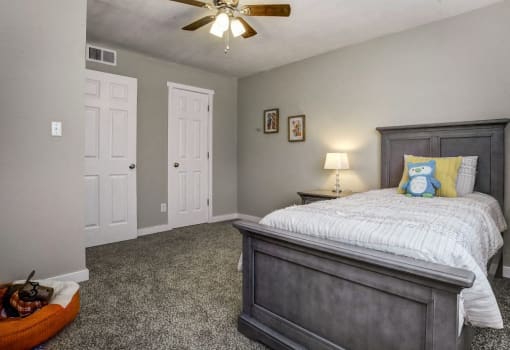 Image of second bedroom with plush carpet and ceiling fan