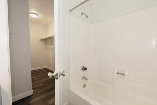 a bathroom with a white tub and a white shower curtain at Bennett Ridge Apartments, Oklahoma City, OK
