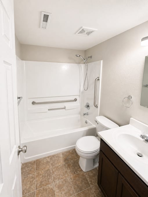 A white bathroom with a toilet, sink, and bathtub.