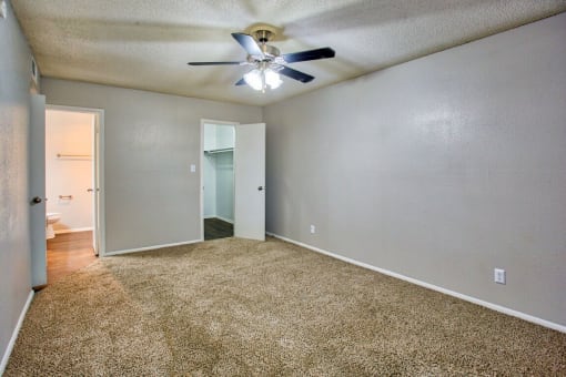 an empty living room with a ceiling fan