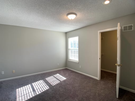 Large carpeted bedroom with window