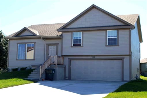 a white house with a driveway and a garage door