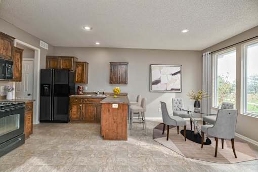 a kitchen and dining room with a table and chairs and a refrigerator