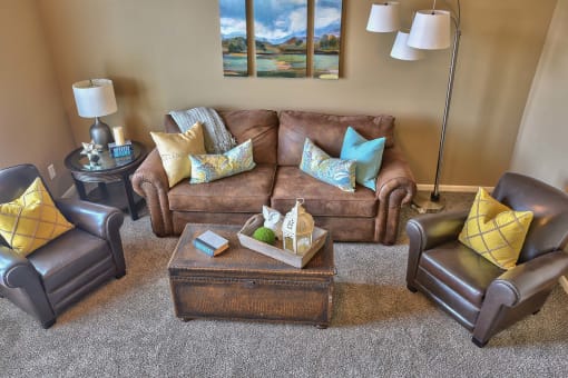 a living room with a couch and chairs and a coffee table