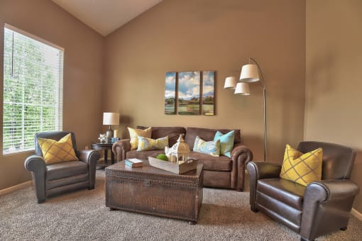 a living room with leather furniture and a large window