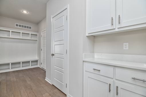 A white kitchen with a door and drawers.