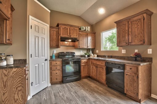 a kitchen with wooden cabinets and black appliances