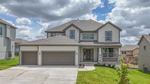 A house with a grey roof and a garage door.