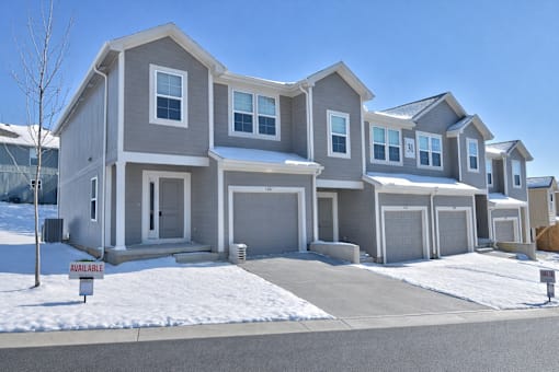 A row of houses with a sign that says "available" in front of the first one.
