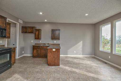 an empty kitchen with an island in the middle of it