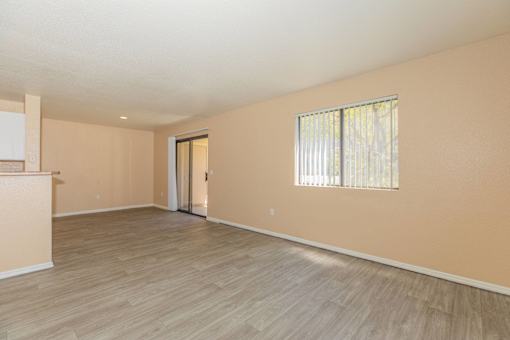 A room with a sliding door and a window with blinds.