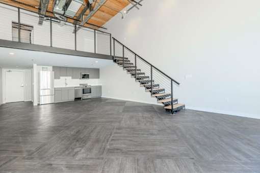 A wooden staircase with metal railings leads up to a second floor.