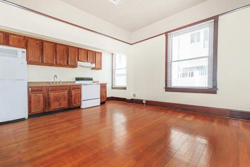 A kitchen with wooden floors and white appliances.