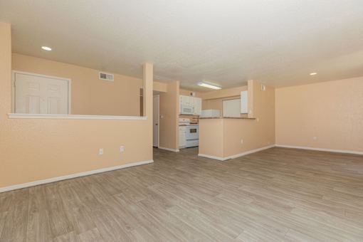 Empty room with light brown walls and wooden flooring.