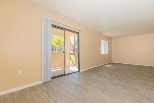A room with a sliding glass door leading to a balcony.