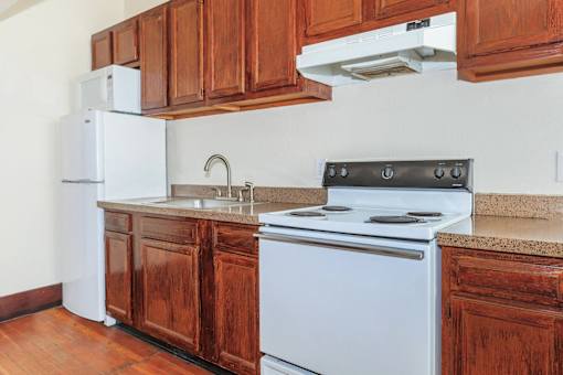 A kitchen with a white stove and wooden cabinets.