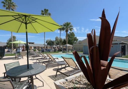 a swimming pool with tables and umbrellas