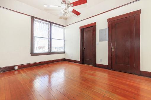 A room with wooden floors and a ceiling fan.