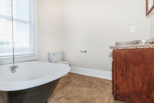 A bathroom with a black tub and brown wooden cabinet.