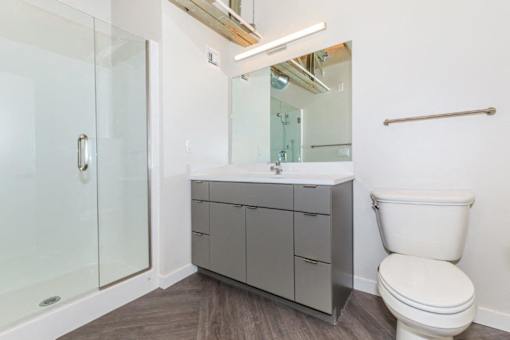 A white toilet sits next to a sink in a modern bathroom.